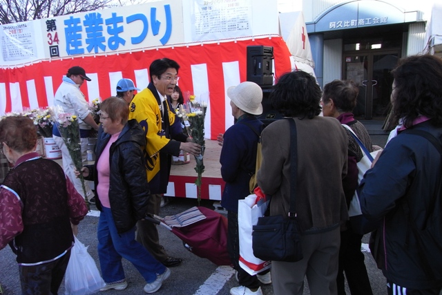 産業まつりで花を配り産業振興をPRする町長