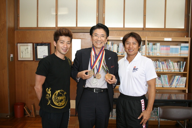 池谷幸雄さんが五輪で獲得したメダルを首にかける町長