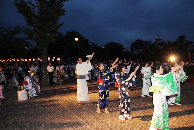 輪になって盆踊りに参加する町長