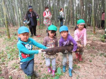大きなたけのこを運ぶ子どもたち。