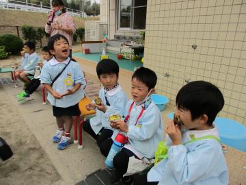 お友達と一緒にお芋を食べる子ども達。