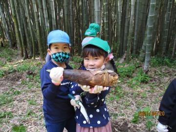 掘れたタケノコを見せる子ども。