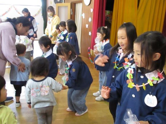 小さい子にプレゼントをもらう年長児
